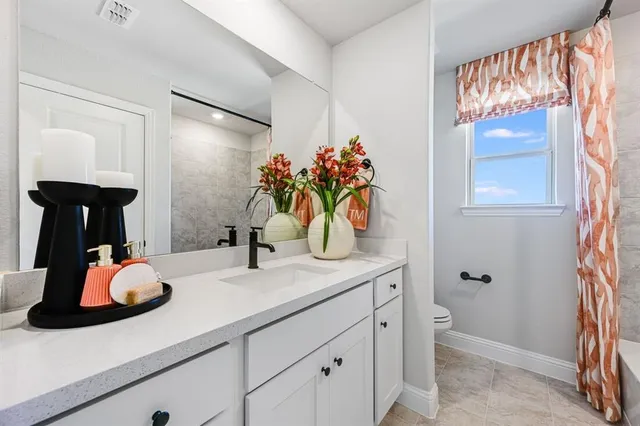 a bathroom with a sink a vanity a mirror a window and a shower