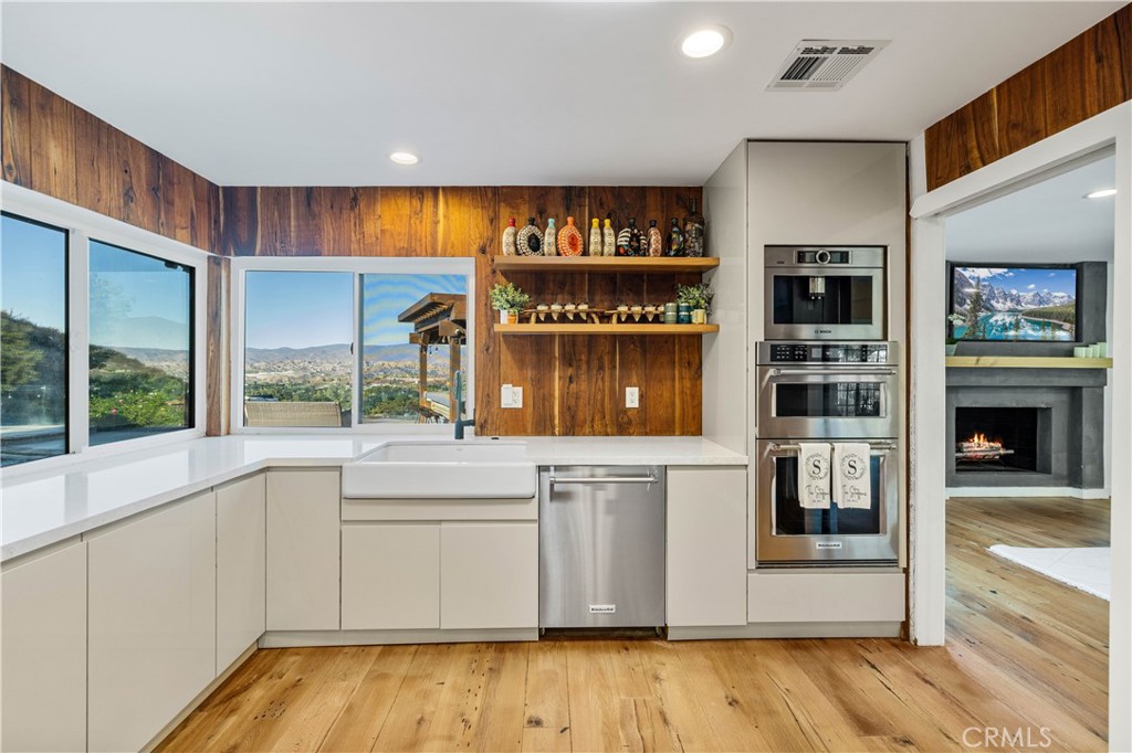 16337 Ravenglen Road Canyon Country, CA 91387 - Photo 12 of 50 a kitchen with stainless steel appliances granite countertop a stove and a refrigerator