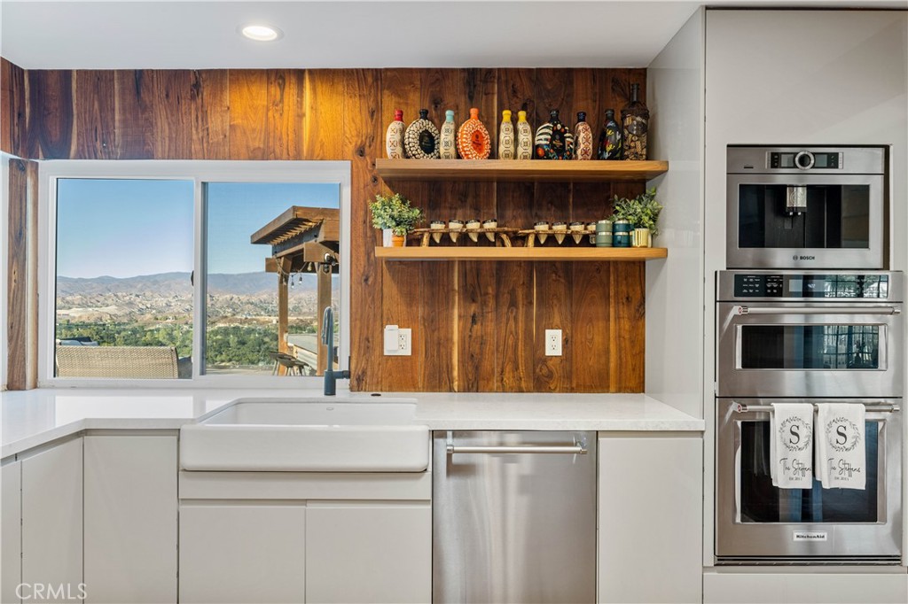 16337 Ravenglen Road Canyon Country, CA 91387 - Photo 13 of 50 a kitchen with stainless steel appliances a cabinets and a counter top space