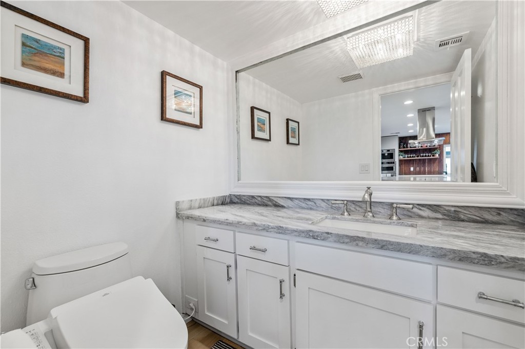 16337 Ravenglen Road Canyon Country, CA 91387 - Photo 17 of 50 a bathroom with a granite countertop toilet sink and mirror