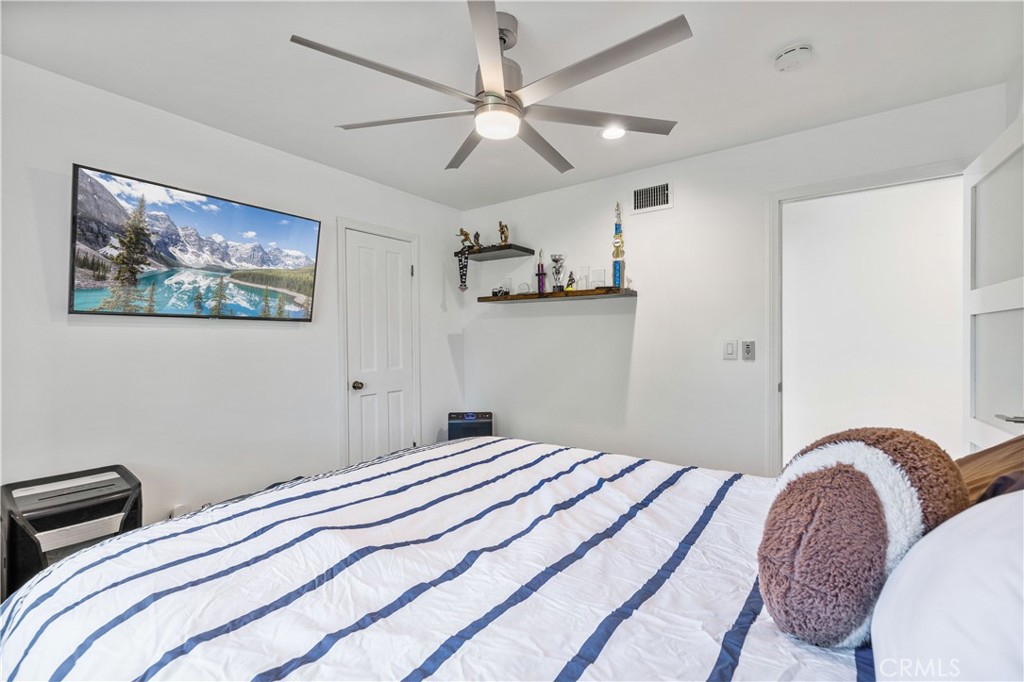 16337 Ravenglen Road Canyon Country, CA 91387 - Photo 20 of 50 a bedroom with bed and a chandelier