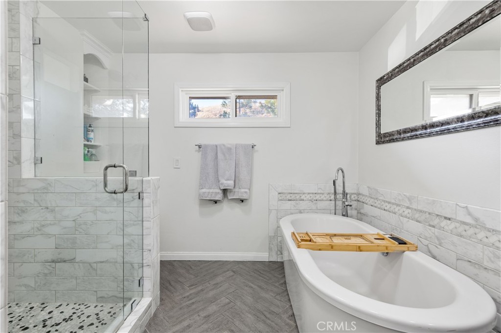 16337 Ravenglen Road Canyon Country, CA 91387 - Photo 31 of 50 a bathroom with a tub a sink and a shower