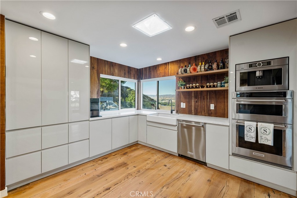 16337 Ravenglen Road Canyon Country, CA 91387 - Photo 10 of 50 a kitchen with stainless steel appliances granite countertop a stove and a microwave