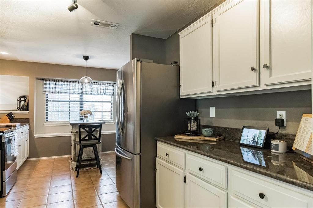 2939 Hunters Point Lane Carrollton, TX 75007 - Photo 18 of 29 a kitchen with stainless steel appliances granite countertop a refrigerator and a stove top oven