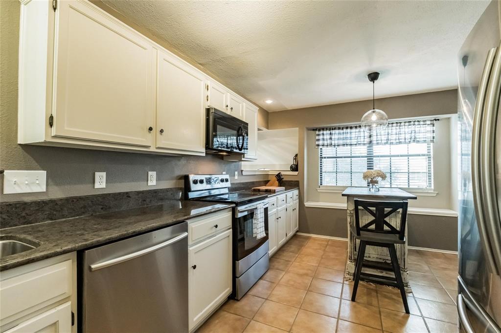 2939 Hunters Point Lane Carrollton, TX 75007 - Photo 20 of 29 a kitchen with stainless steel appliances granite countertop a stove a sink and a microwave