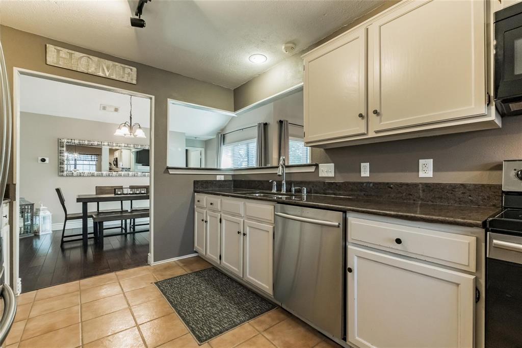 2939 Hunters Point Lane Carrollton, TX 75007 - Photo 6 of 29 a kitchen with stainless steel appliances granite countertop a stove a sink and a microwave