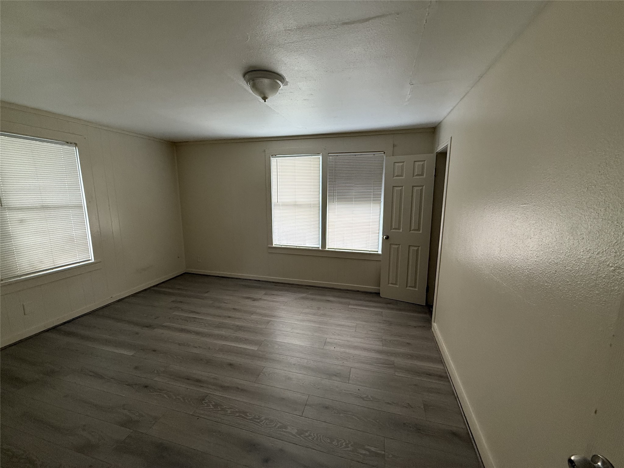 1314 East Power Avenue Victoria, TX 77901 - Photo 23 of 26 an empty room with wooden floor and windows