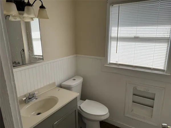 a bathroom with a sink a toilet and a window