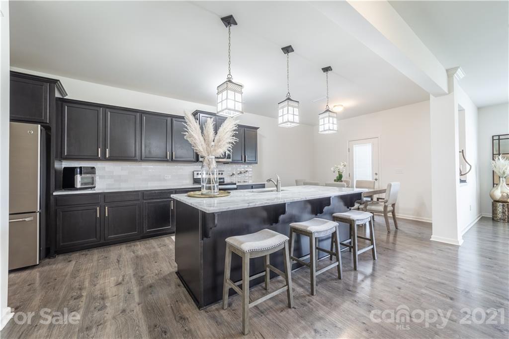 515 Comfort Way Locust, NC 28097 - Photo 12 of 31 a kitchen with a dining table a sink appliances and cabinets
