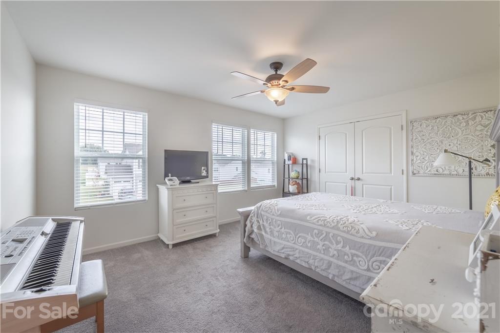 515 Comfort Way Locust, NC 28097 - Photo 19 of 31 a spacious bedroom with a bed a window and a couch