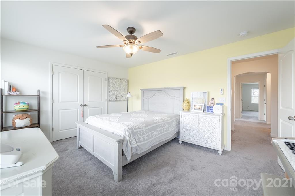 515 Comfort Way Locust, NC 28097 - Photo 20 of 31 a spacious bedroom with a bed and a chandelier