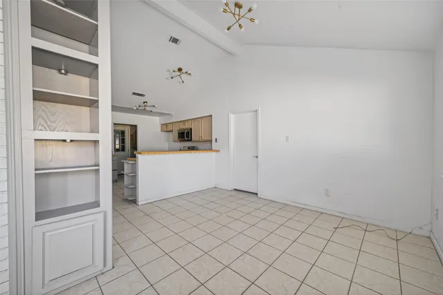 a view of a kitchen with wooden cabinet and a refrigerator