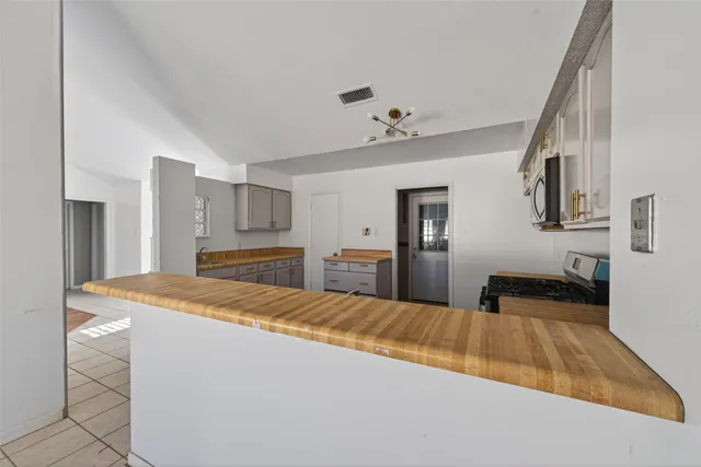 a kitchen with cabinets stainless steel appliances and a counter space
