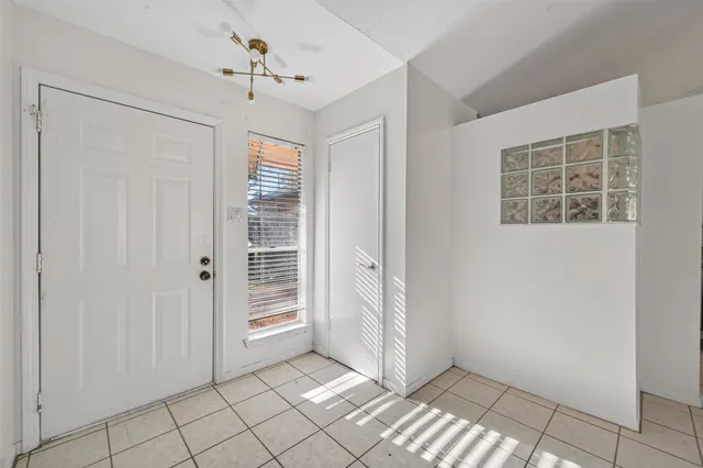 an empty room with windows and fireplace