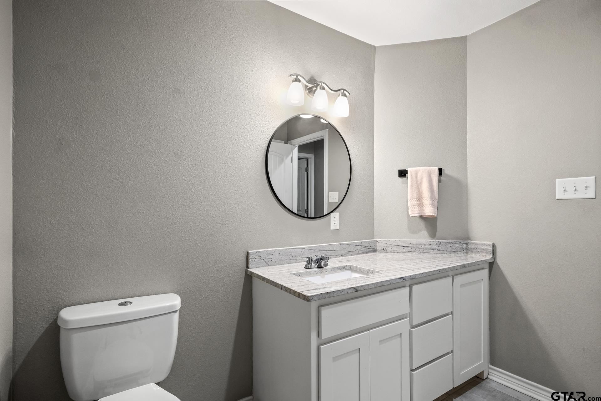655 Daingerfield Street Pittsburg, TX 75686 - Photo 19 of 27 a bathroom with a toilet sink and mirror