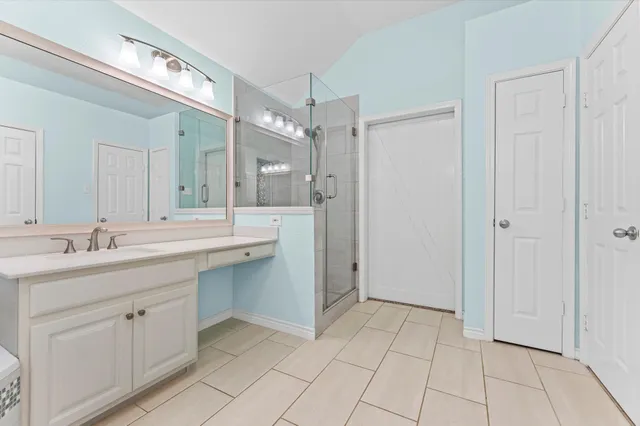 a spacious bathroom with a tub a sink and mirror