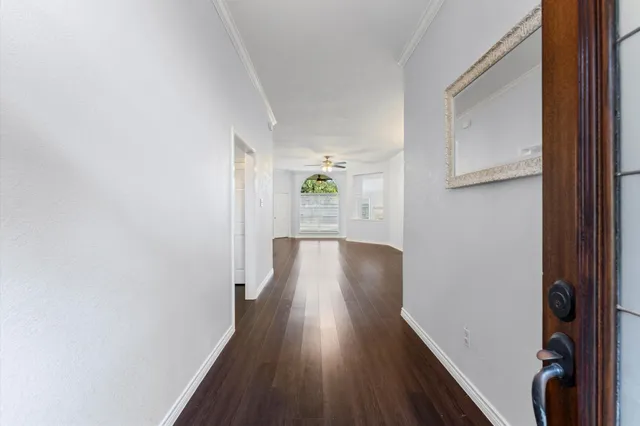 a view of a hallway with wooden floor and a window