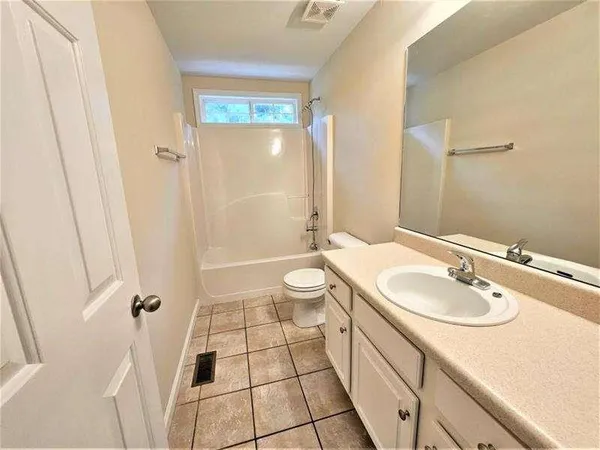 a bathroom with a sink a toilet a mirror and shower