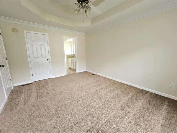 an empty room with a ceiling fan and window
