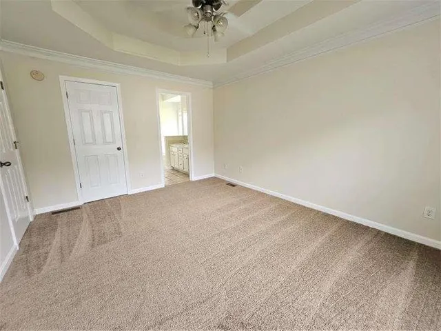 an empty room with a ceiling fan and window