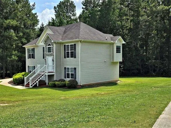 a view of a house with a yard and sitting area