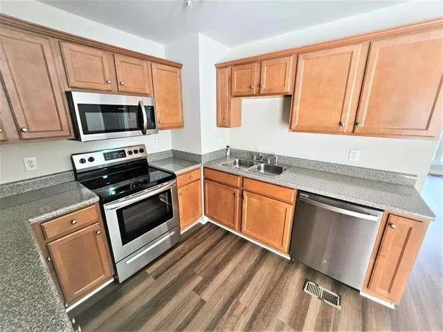 a kitchen with stainless steel appliances a stove sink microwave and cabinets