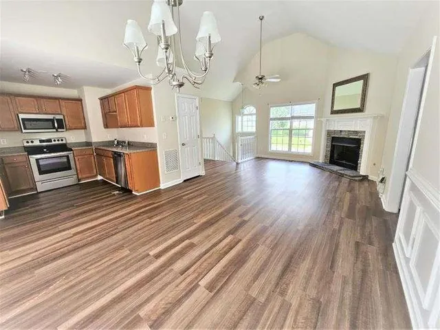 an open kitchen view with fireplace and wooden floor