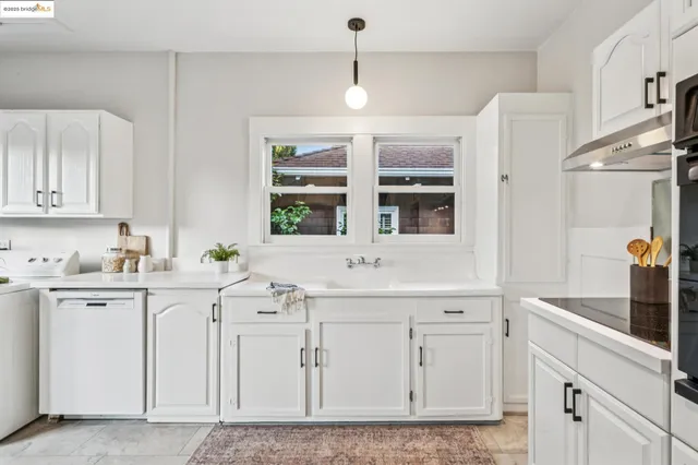 a kitchen with white cabinets and white appliances