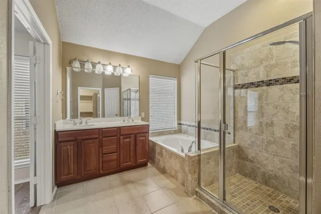 a bathroom with a tub sink shower and mirror