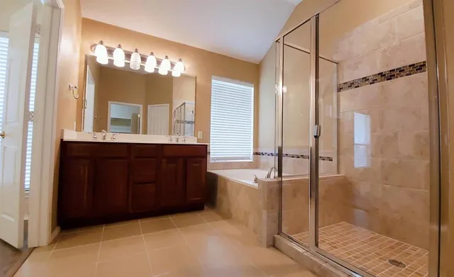 a bathroom with a tub a sink and a large mirror