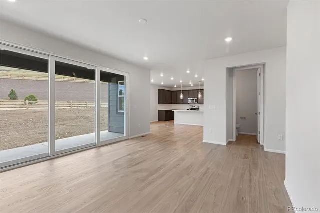 a view of empty room with wooden floor and a fireplace
