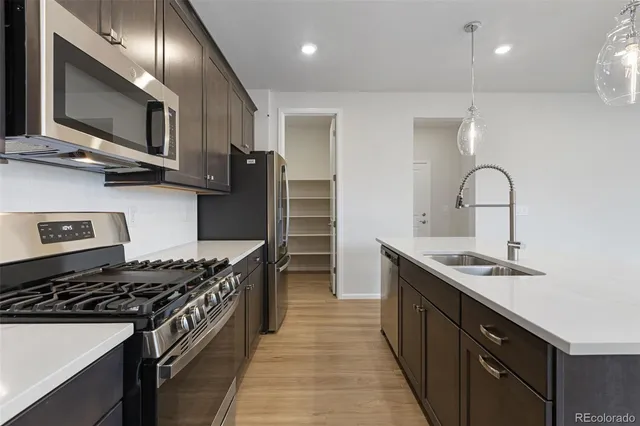 a kitchen with stainless steel appliances granite countertop a sink stove and refrigerator