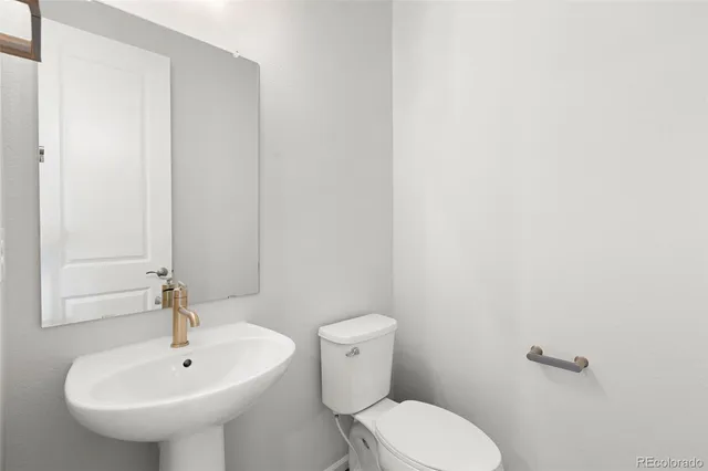 a bathroom with a sink a toilet and mirror