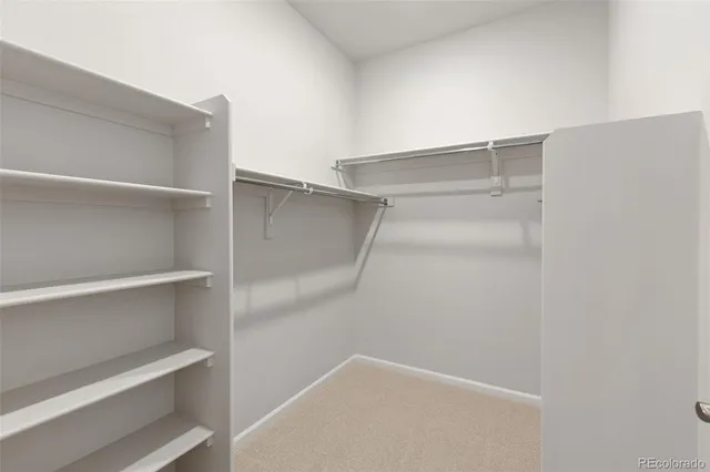a view of walk in closet with empty racks