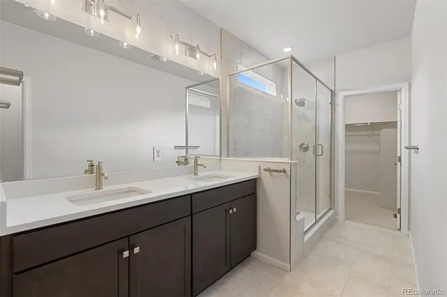 a bathroom with a double vanity sink mirror and shower