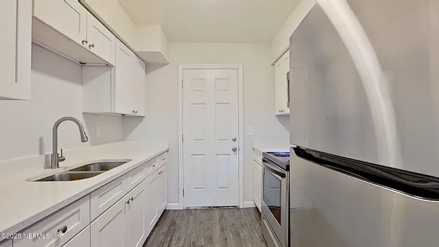 a kitchen with white cabinets and a sink