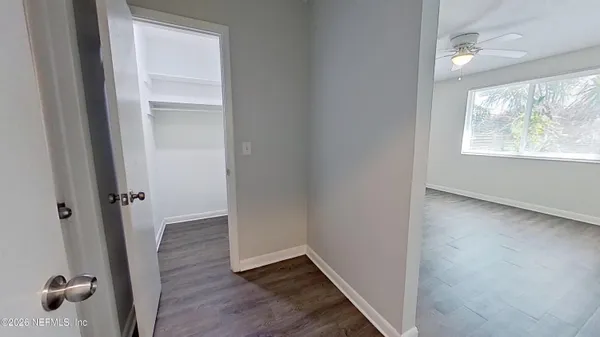 an empty room with wooden floor and a window