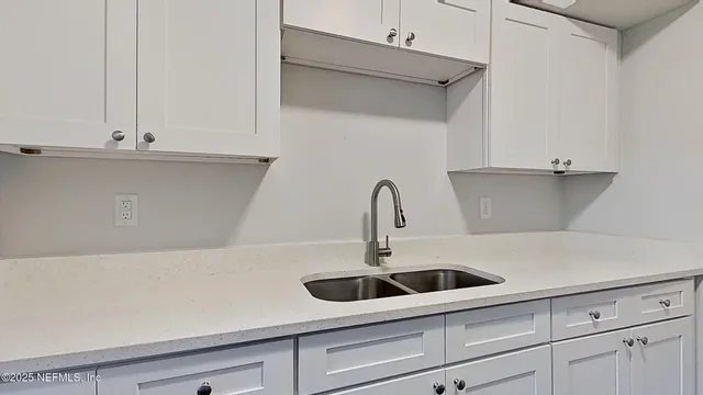 a view of a hallway with wooden floor and a bathroom