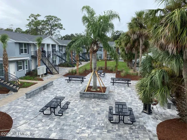 a view of a house with backyard water fountain and sitting area