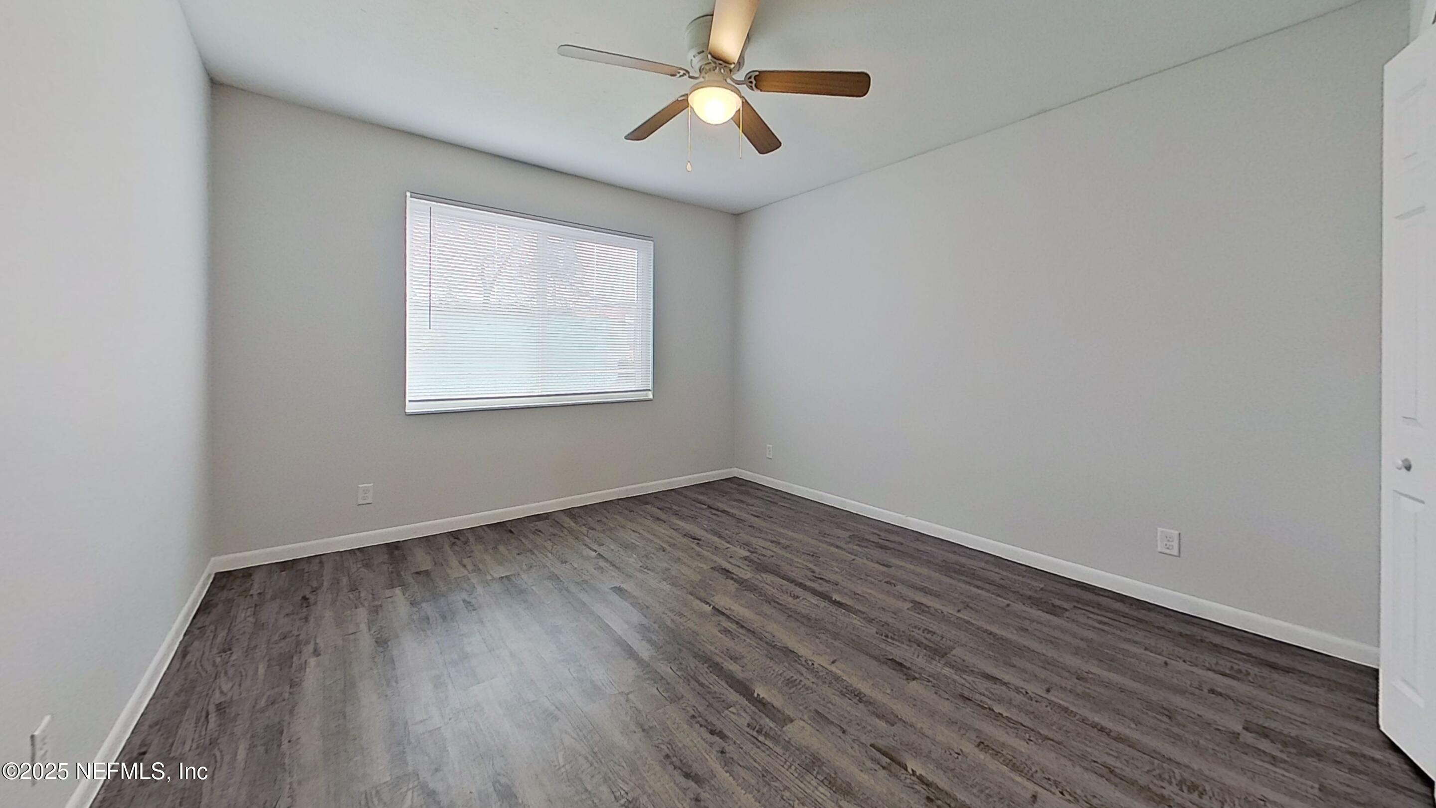 2216 Spring Park Road, Unit 6 Jacksonville, FL 32207 - Photo 28 of 32 an empty room with wooden floor ceiling fan and windows