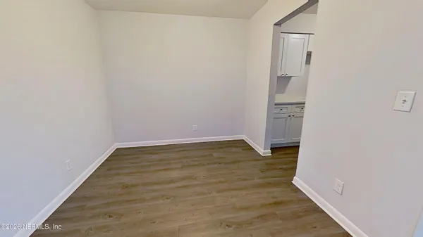a view of empty room with wooden floor