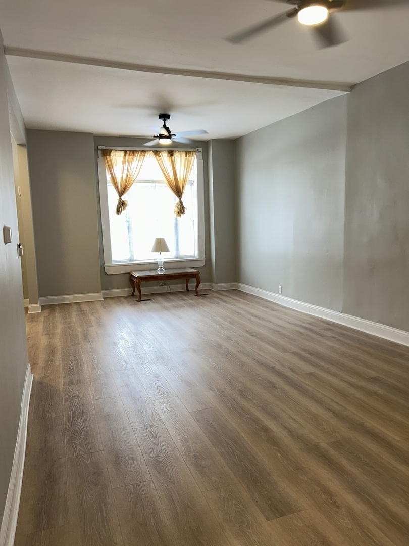 637 West 59th Street Chicago, IL 60621 - Photo 2 of 8 an empty room with wooden floor and windows