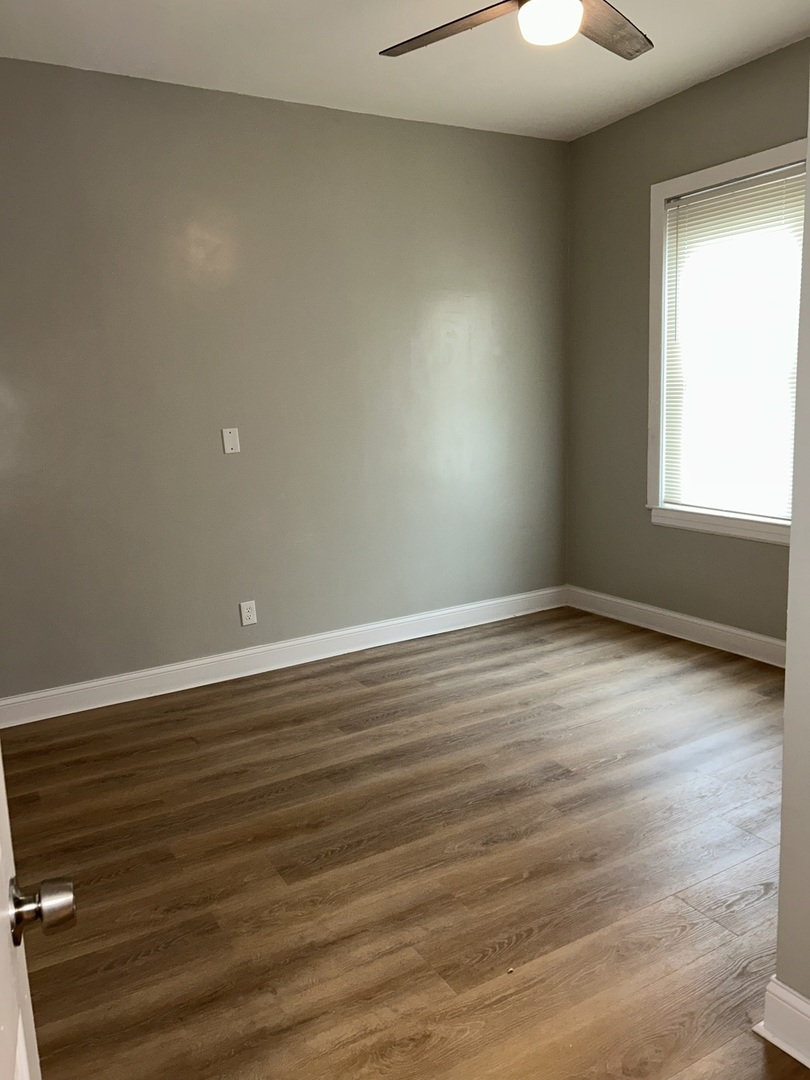 637 West 59th Street Chicago, IL 60621 - Photo 6 of 8 wooden floor in an empty room with a window
