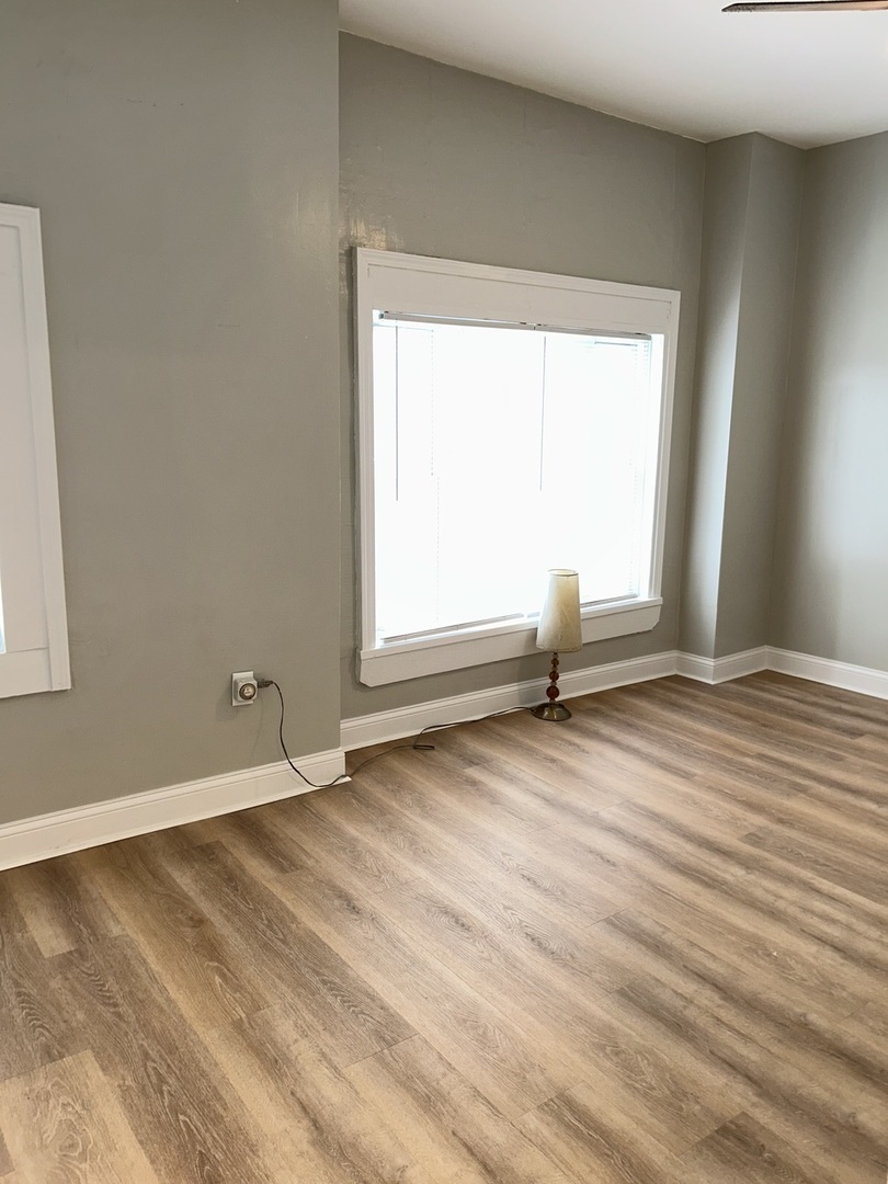 637 West 59th Street Chicago, IL 60621 - Photo 7 of 8 an empty room with wooden floor and windows