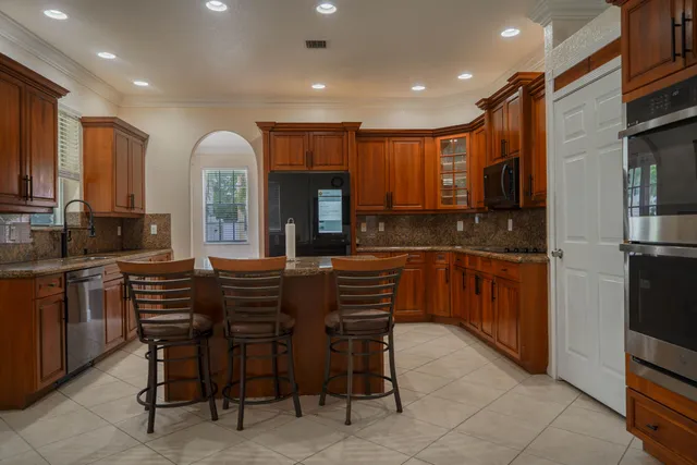 a kitchen with stainless steel appliances kitchen island granite countertop a sink and cabinets