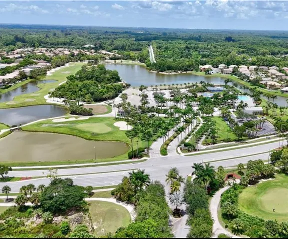 an aerial view of a house with a yard and lake view
