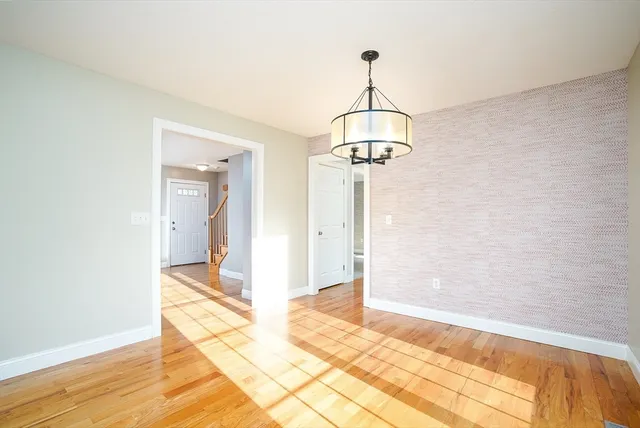 a view of a room with a chandelier and wooden floor