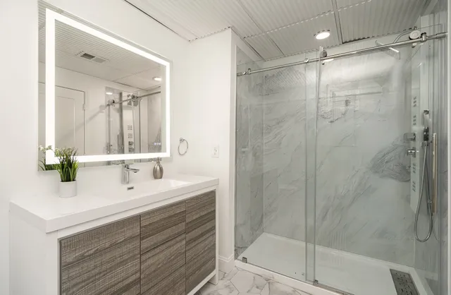 a bathroom with a double vanity sink mirror and shower