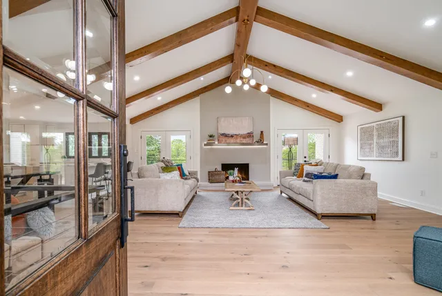 a living room with furniture a fireplace and a chandelier