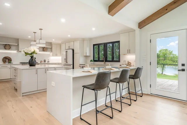 a kitchen with stainless steel appliances kitchen island granite countertop a sink and cabinets